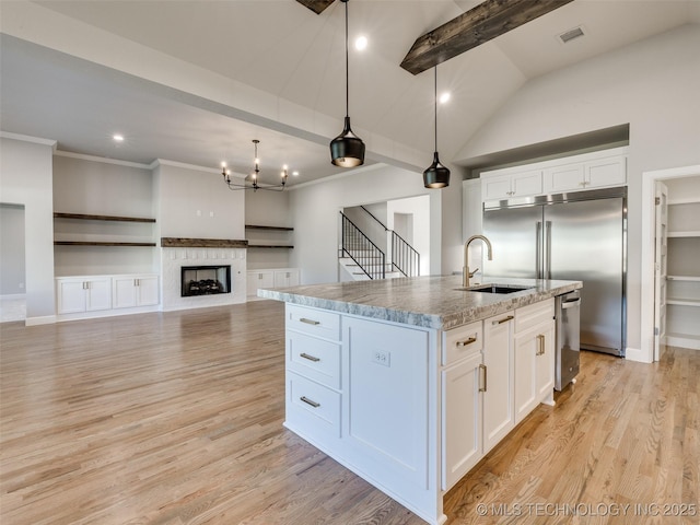 4010 W Baton Rouge St, Broken Arrow, OK 74011 - kitchen featuring a sink, appliances with stainless steel finishes, white cabinets, vaulted ceiling, and a center island with sink