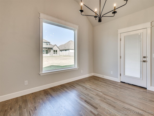 4010 W Baton Rouge St, Broken Arrow, OK 74011 - unfurnished dining area with a chandelier, plenty of natural light, baseboards, wood finished floors, and vaulted ceiling