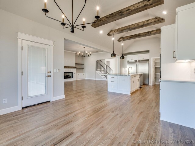 4010 W Baton Rouge St, Broken Arrow, OK 74011 - kitchen with a chandelier, a sink, open floor plan, white cabinetry, and light wood-style floors