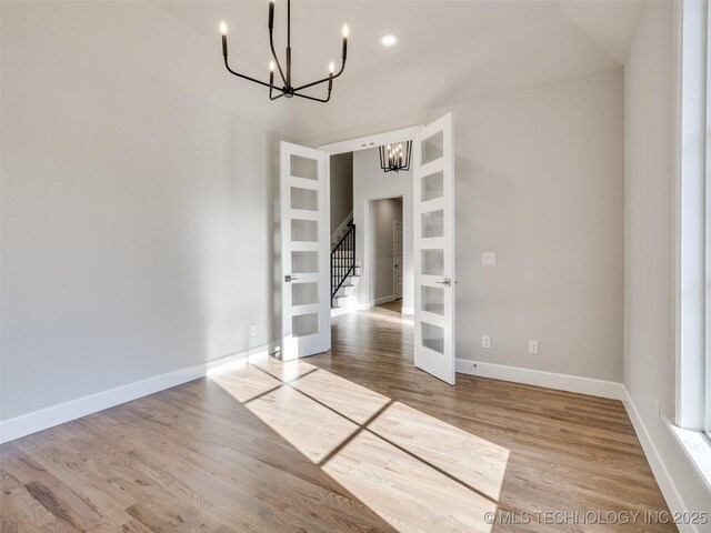 4010 W Baton Rouge St, Broken Arrow, OK 74011 - unfurnished dining area featuring a chandelier, french doors, wood finished floors, baseboards, and stairway