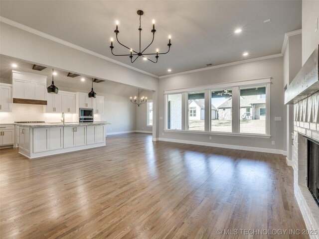 4010 W Baton Rouge St, Broken Arrow, OK 74011 - unfurnished living room with a chandelier, a fireplace, a sink, baseboards, and ornamental molding
