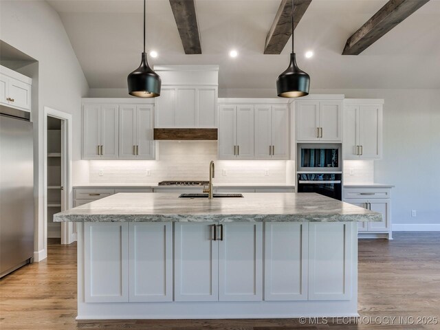 4010 W Baton Rouge St, Broken Arrow, OK 74011 - kitchen with black appliances, a sink, white cabinetry, backsplash, and a center island with sink