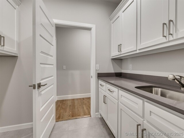 4010 W Baton Rouge St, Broken Arrow, OK 74011 - kitchen featuring dark countertops, a sink, white cabinetry, and baseboards