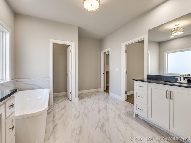 11220 S Fir Ave W, Jenks, OK 74037 - bathroom with a freestanding tub, vanity, marble look tiles, and baseboards