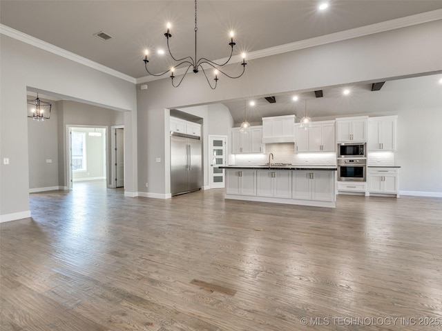 11220 S Fir Ave W, Jenks, OK 74037 - unfurnished living room with a sink, a chandelier, ornamental molding, baseboards, and wood finished floors