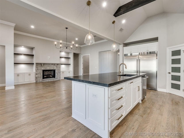 11220 S Fir Ave W, Jenks, OK 74037 - kitchen featuring a sink, dark countertops, ornamental molding, an island with sink, and white cabinets