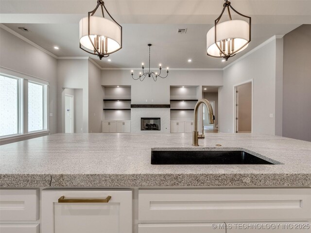 4011 W Baton Rouge St, Broken Arrow, OK 74011 - kitchen with a sink, open floor plan, ornamental molding, white cabinetry, and light stone counters
