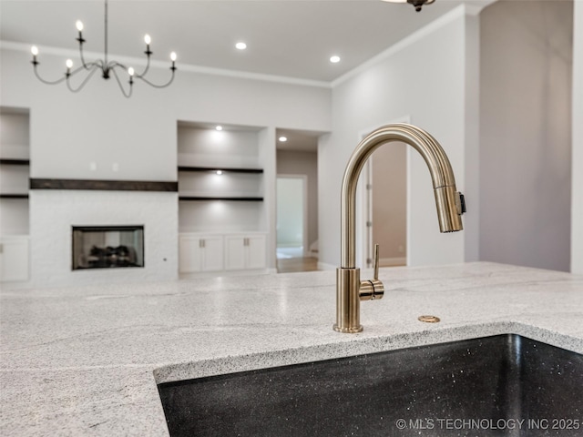 4011 W Baton Rouge St, Broken Arrow, OK 74011 - kitchen view of a sink, built in features, light stone counters, a fireplace, and ornamental molding