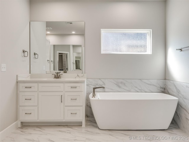 4011 W Baton Rouge St, Broken Arrow, OK 74011 - bathroom with vanity, a freestanding tub, marble finish flooring, tile walls, and wainscoting