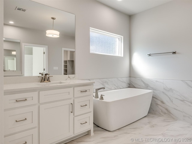 4011 W Baton Rouge St, Broken Arrow, OK 74011 - full bath with marble look tile flooring, a freestanding tub, tile walls, vanity, and a wainscoted wall