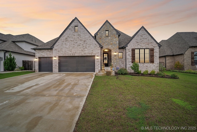 12419 S 102nd E Ave, Bixby, OK 74008 - french country home with an attached garage, a front lawn, driveway, and brick siding