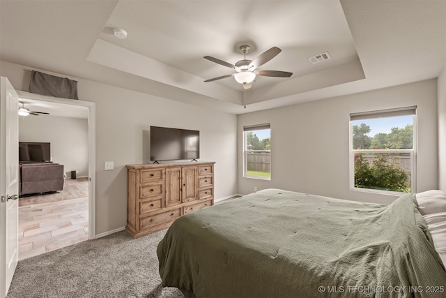 13010 E 122nd Pl, Collinsville, OK 74021 - bedroom featuring a tray ceiling, light carpet, baseboards, and ceiling fan