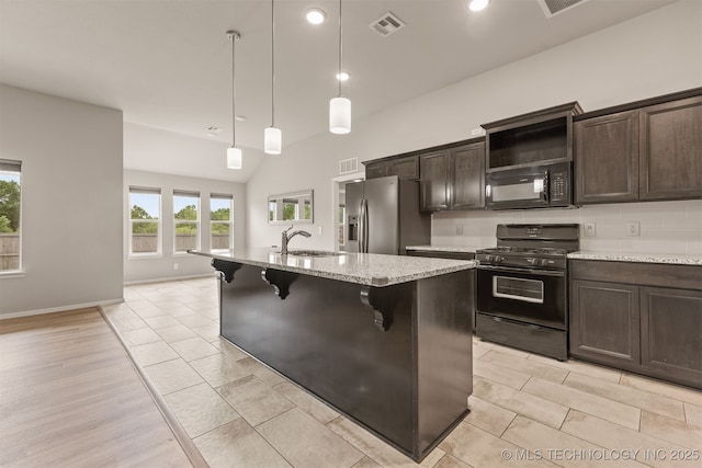 13010 E 122nd Pl, Collinsville, OK 74021 - kitchen featuring black appliances, a sink, a kitchen island with sink, dark brown cabinets, and a kitchen breakfast bar