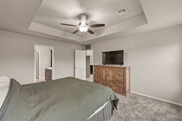 13010 E 122nd Pl, Collinsville, OK 74021 - bedroom with a tray ceiling, baseboards, light carpet, a ceiling fan, and connected bathroom
