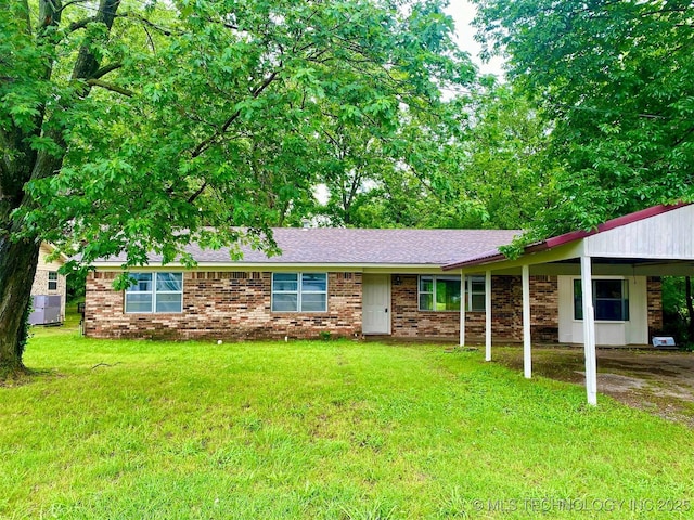 305 N 10th St, Hartshorne, OK 74547 - view of front facade with a carport, a front lawn, a shingled roof, and brick siding