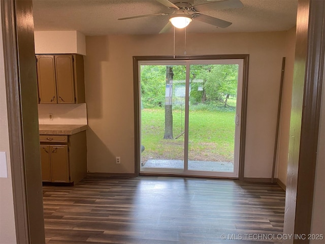 305 N 10th St, Hartshorne, OK 74547 - unfurnished dining area with dark wood-style floors, a textured ceiling, and ceiling fan