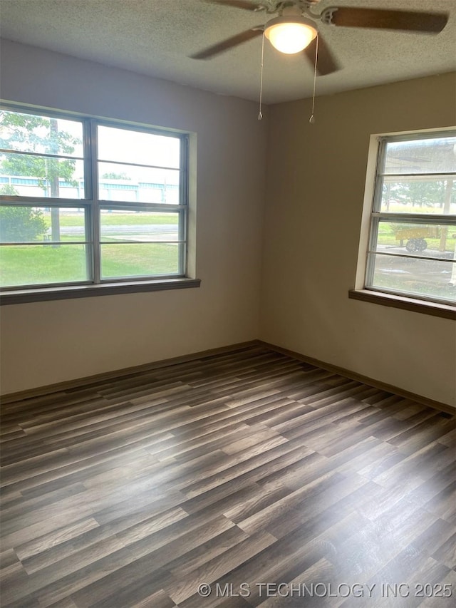 305 N 10th St, Hartshorne, OK 74547 - spare room with plenty of natural light, a ceiling fan, dark wood finished floors, and a textured ceiling