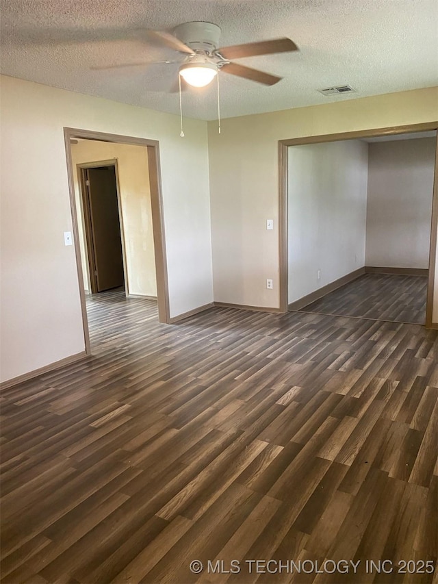 305 N 10th St, Hartshorne, OK 74547 - empty room with dark wood finished floors, a ceiling fan, and a textured ceiling