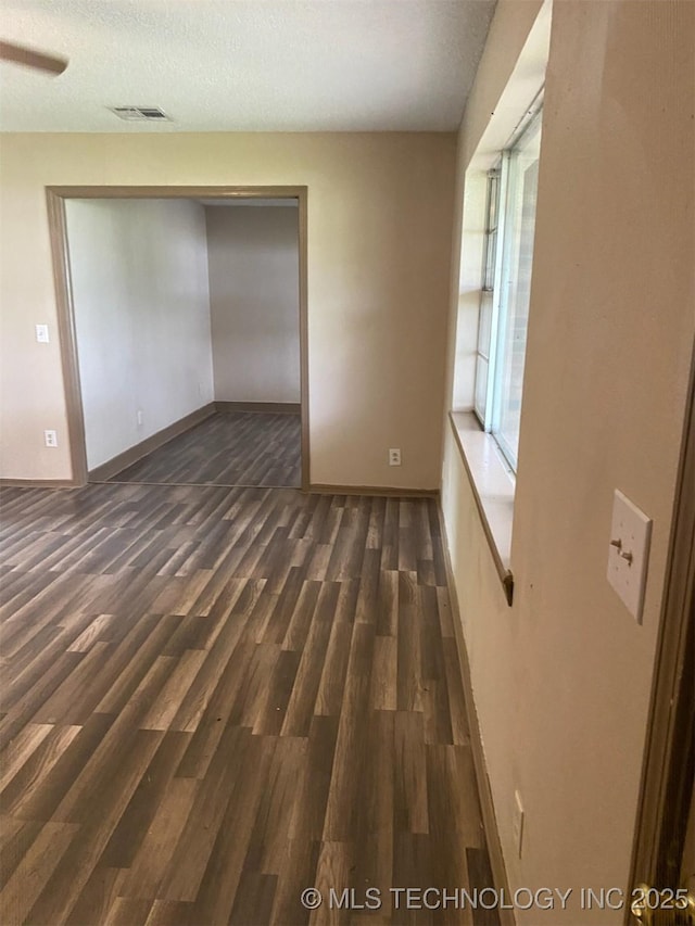 305 N 10th St, Hartshorne, OK 74547 - unfurnished room with dark wood finished floors and a textured ceiling