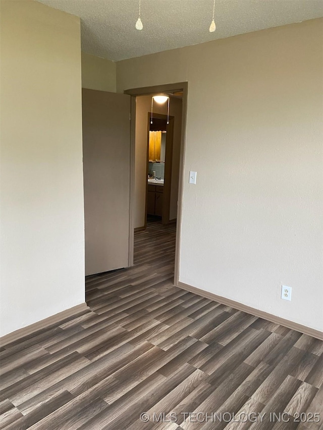 305 N 10th St, Hartshorne, OK 74547 - empty room featuring dark wood-type flooring and a textured ceiling