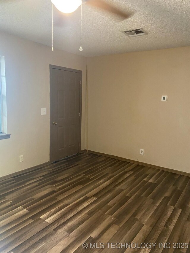 305 N 10th St, Hartshorne, OK 74547 - unfurnished room with dark wood-type flooring and a textured ceiling