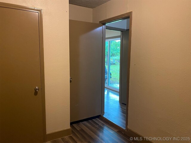 305 N 10th St, Hartshorne, OK 74547 - hall featuring dark wood-style flooring, a textured wall, and a textured ceiling