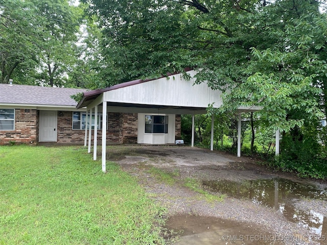 305 N 10th St, Hartshorne, OK 74547 - single story home with a carport, driveway, a front yard, and brick siding