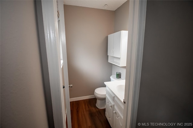 11612 E 28th St, Tulsa, OK 74129 - bathroom featuring wood finished floors, vanity, toilet, and baseboards