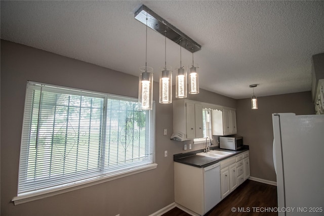 11612 E 28th St, Tulsa, OK 74129 - kitchen featuring white appliances, a textured ceiling, a sink, dark countertops, and baseboards