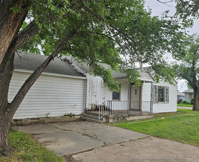 737 W Doolin Ave, Blackwell, OK 74631 - view of front of home with a shingled roof, a front lawn, and covered porch