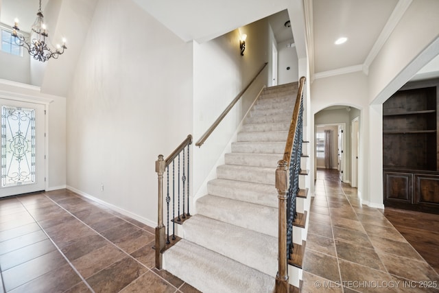 16210 E 49th St, Tulsa, OK 74134 - tiled entrance foyer with arched walkways, a towering ceiling, stairway, a chandelier, and baseboards