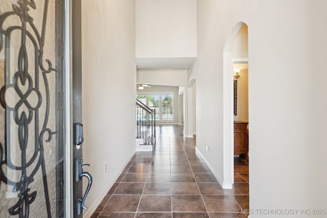 16210 E 49th St, Tulsa, OK 74134 - foyer entrance with arched walkways, dark tile patterned floors, stairway, baseboards, and ceiling fan