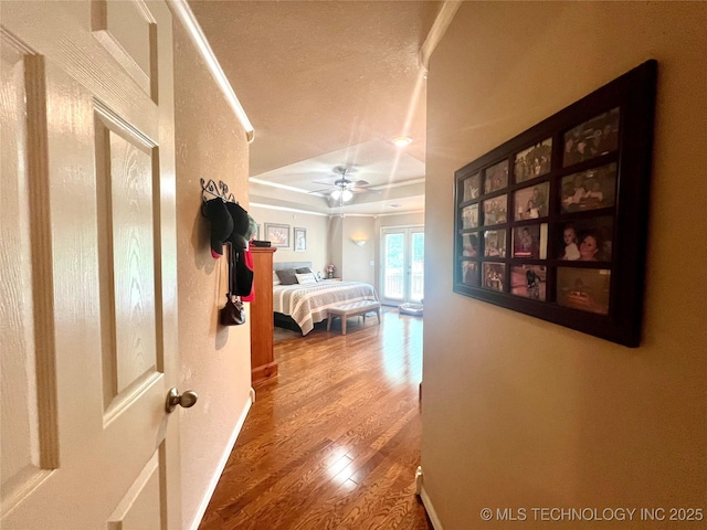 1403 NW Mimosa Cir, Stigler, OK 74462 - hall with wood finished floors, a raised ceiling, and a textured ceiling