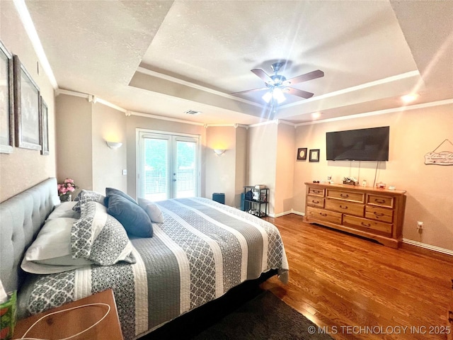 1403 NW Mimosa Cir, Stigler, OK 74462 - bedroom with a tray ceiling, ornamental molding, access to exterior, baseboards, and wood finished floors