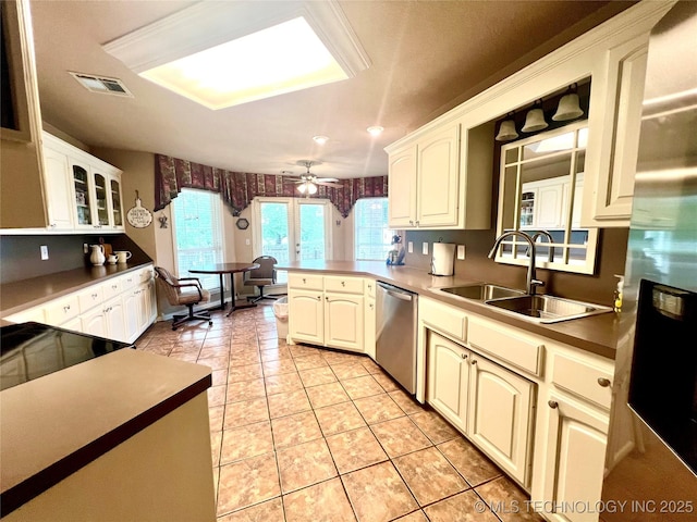 1403 NW Mimosa Cir, Stigler, OK 74462 - kitchen featuring stainless steel appliances, a sink, a ceiling fan, light tile patterned flooring, and a peninsula