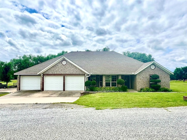 1403 NW Mimosa Cir, Stigler, OK 74462 - view of front of home with a front lawn, a garage, concrete driveway, and brick siding