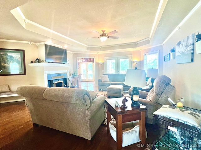 1403 NW Mimosa Cir, Stigler, OK 74462 - living room with a tray ceiling, a ceiling fan, wood finished floors, a fireplace, and crown molding