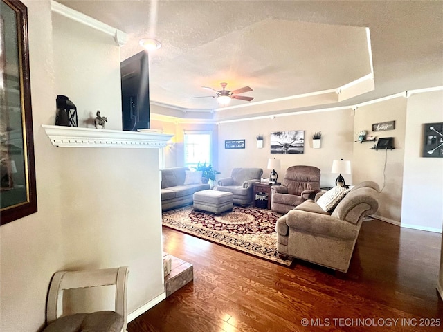 1403 NW Mimosa Cir, Stigler, OK 74462 - living room featuring a raised ceiling, a ceiling fan, wood finished floors, and crown molding