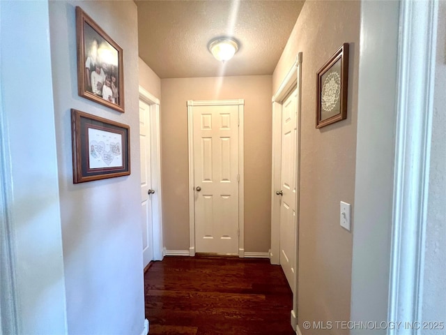 1403 NW Mimosa Cir, Stigler, OK 74462 - corridor featuring a textured ceiling, dark wood-type flooring, and baseboards