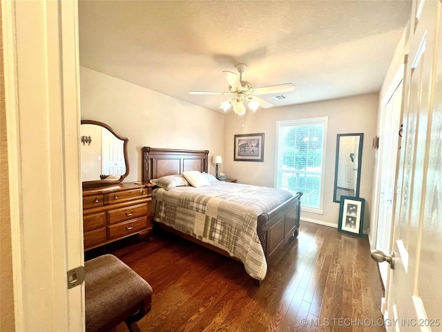 1403 NW Mimosa Cir, Stigler, OK 74462 - bedroom with dark wood finished floors, ceiling fan, and baseboards