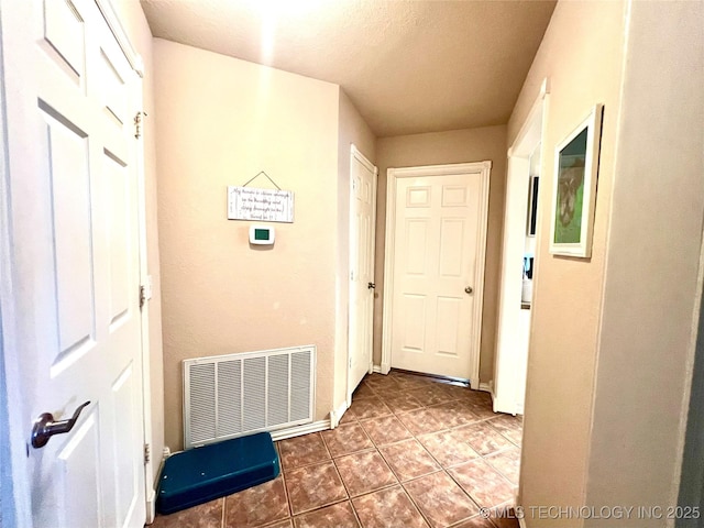 1403 NW Mimosa Cir, Stigler, OK 74462 - corridor featuring tile patterned flooring, baseboards, and a textured ceiling