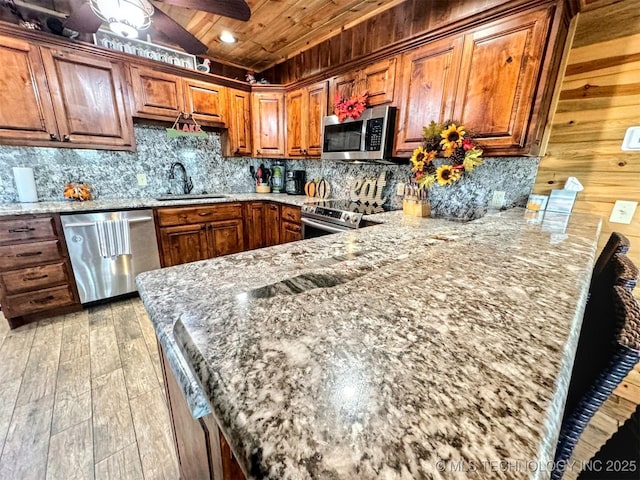 31663 S 530th Rd, Cookson, OK 74427 - kitchen with stainless steel appliances, a sink, wood ceiling, light wood-style flooring, and a peninsula