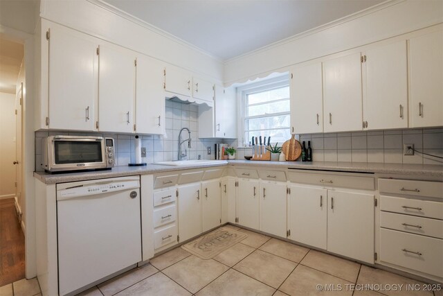 4524 E 45th St, Tulsa, OK 74135 - kitchen featuring dishwasher, a sink, tasteful backsplash, crown molding, and white cabinetry