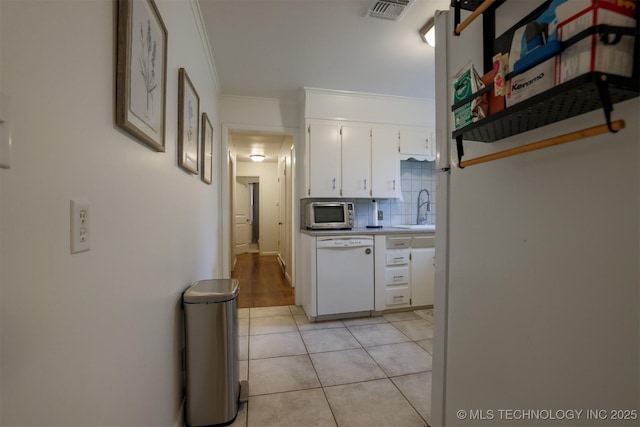 4524 E 45th St, Tulsa, OK 74135 - kitchen with white dishwasher, a sink, ornamental molding, white cabinets, and stainless steel microwave