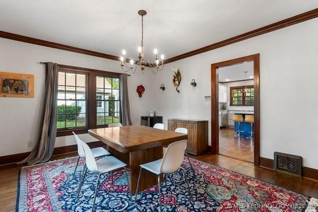 1701 S Rockford Ave, Tulsa, OK 74120 - dining space featuring a chandelier, wood finished floors, crown molding, plenty of natural light, and baseboards