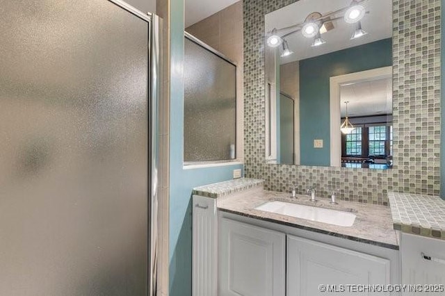 1701 S Rockford Ave, Tulsa, OK 74120 - full bath featuring vanity, a shower with shower door, and tasteful backsplash