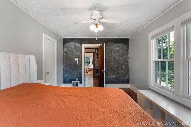 1701 S Rockford Ave, Tulsa, OK 74120 - bedroom with crown molding, wood finished floors, a textured ceiling, ceiling fan, and baseboards