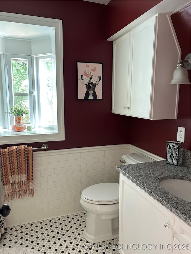 1241 E 29th St, Tulsa, OK 74114 - half bath featuring vanity, a wainscoted wall, tile patterned floors, and tile walls