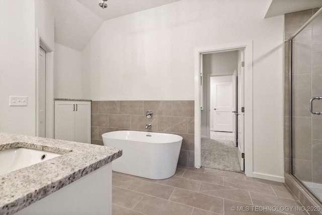 6512 N 27th St, Broken Arrow, OK 74014 - full bath with vanity, a stall shower, a freestanding tub, tile walls, and tile patterned flooring