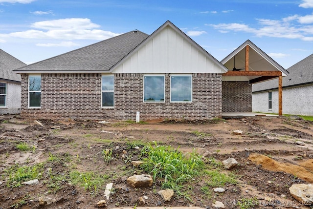 6512 N 27th St, Broken Arrow, OK 74014 - back of house with board and batten siding, brick siding, and roof with shingles